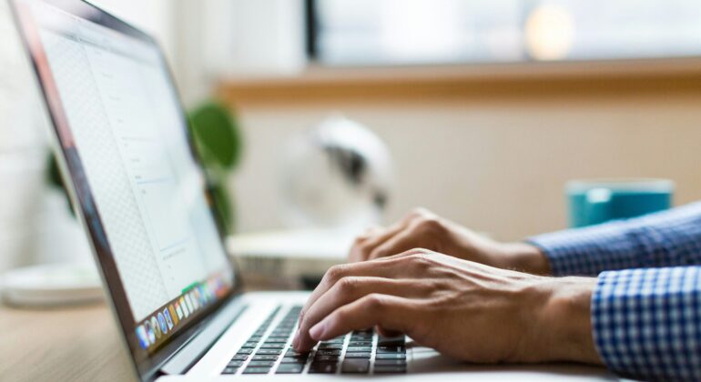 person typing on silver Macbook