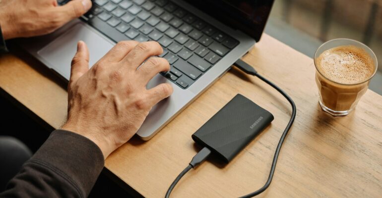 A man sitting at a table using a laptop computer