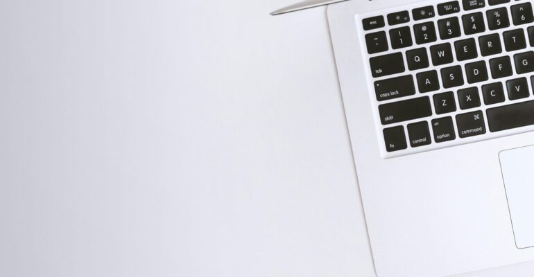 Free Aerial view of a sleek laptop keyboard on a clean, white surface, ideal for tech backgrounds. Stock Photo