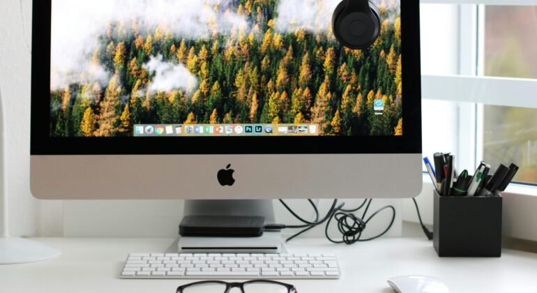 Free Stylish home office workspace featuring a computer setup with accessories. Stock Photo