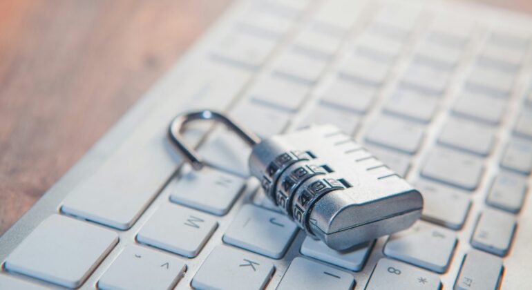 A combination lock rests on a computer keyboard.